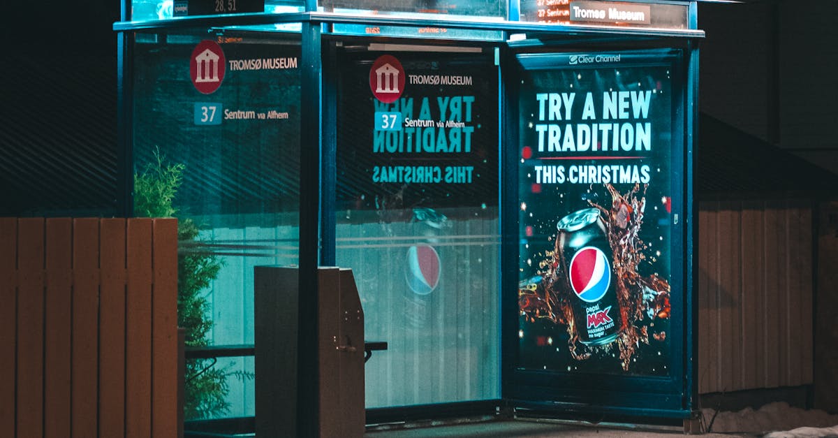 An empty bus stop with glowing advertisements at night, reflecting on wet pavement.